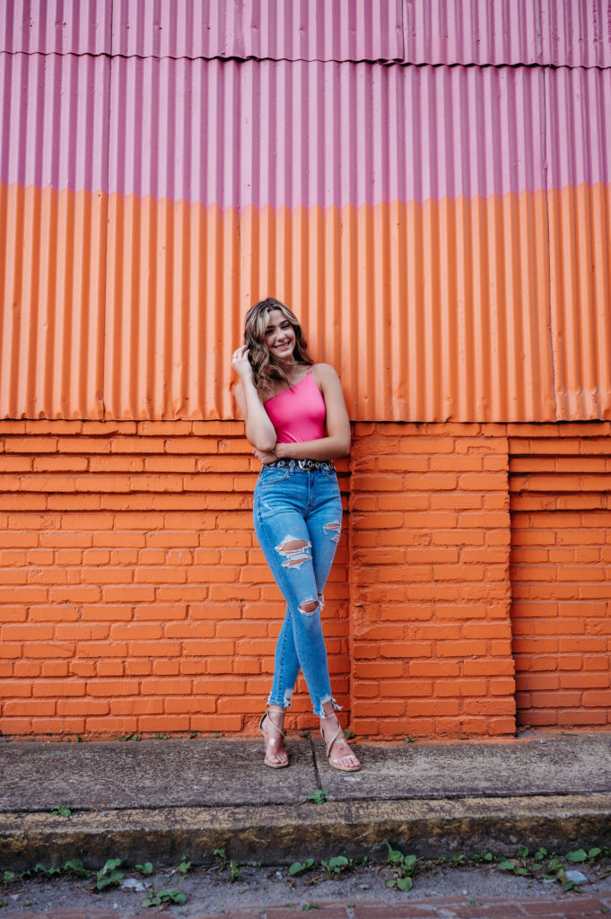 Hubbard high school senior pictures against bright pink and orange building in pittsburgh

